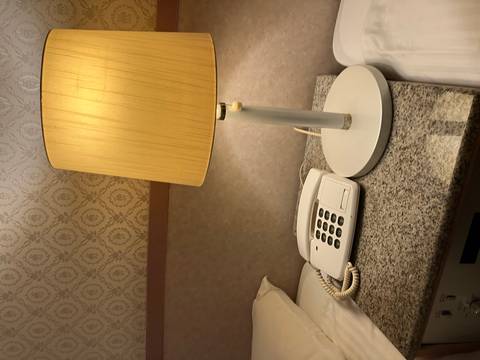 Bedside table with a lamp and a telephone.