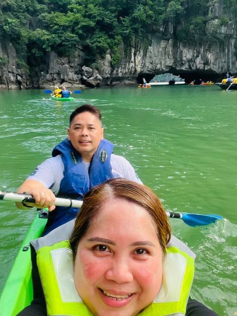      Close-up of a person kayaking on a green river.
  