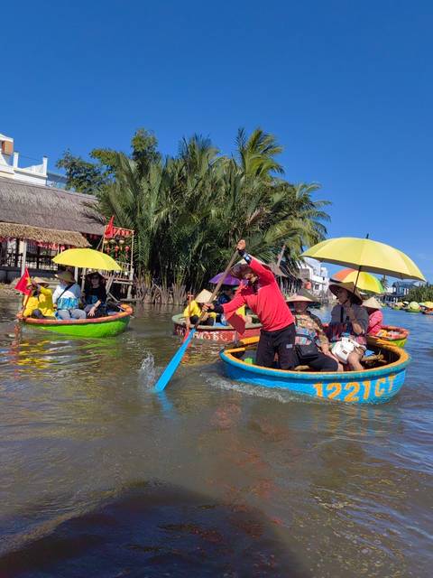       Tourists enjoying a traditional round basket boat ride in calm waters.
  