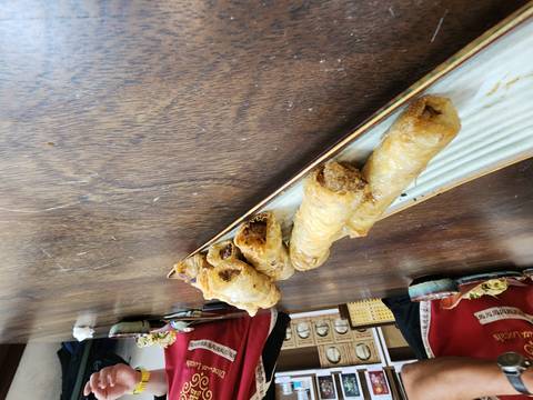       Platter of fried spring rolls on a wooden table.
  