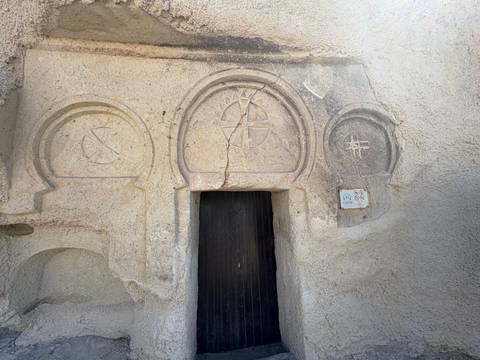       Ancient rock carvings surrounding a wooden door.
  