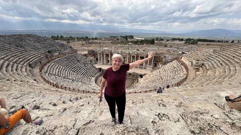 Person posing in an ancient amphitheater.