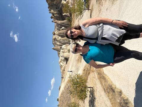       Two women posing in front of unique natural rock formations.
  