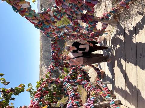       Two women posing on a decorated frame in a scenic area.
  