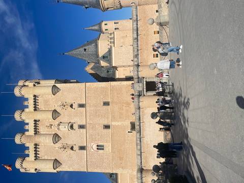 Historic castle with tourists outside.