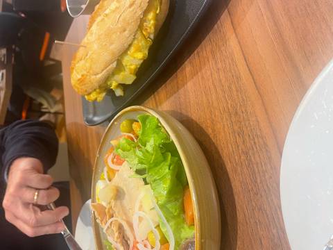 Salad and sandwich on a table in a restaurant.