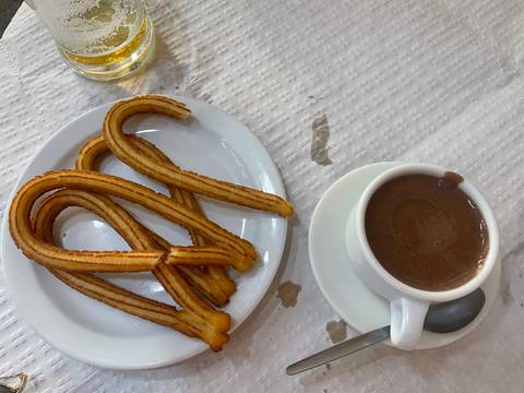 Churros with hot chocolate on a table.