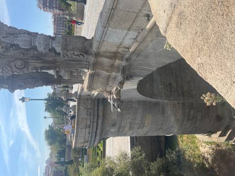 Stone bridge with tourists under blue sky.