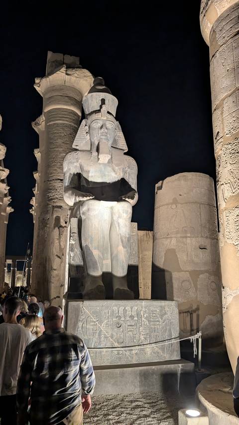Statue of an ancient Egyptian pharaoh at night.