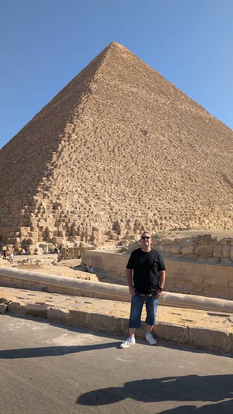 Person standing in front of the Great Pyramid of Giza.