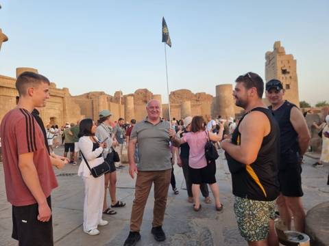       Group of tourists visiting an ancient Egyptian temple with large columns.
  