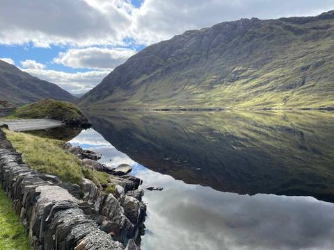       Scenic landscape with mountains and a reflective lake.
  