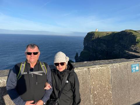       Couple posing with an ocean backdrop and cliffs.
  