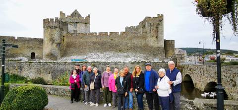       Group posing in front of a historic castle.
  