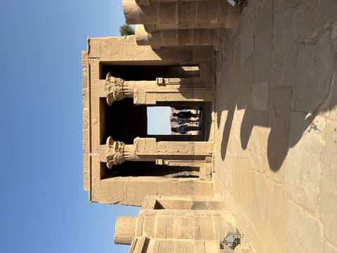 Tourists walking through ancient Egyptian ruins.