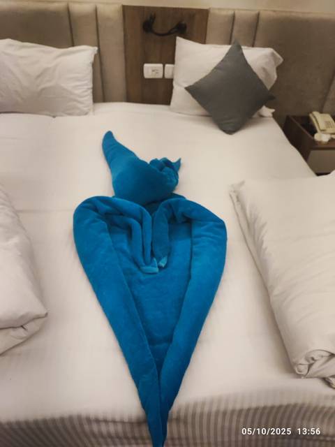       Blue towel folded on a bed.
  