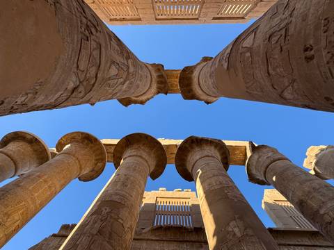 View of tall columns from below with blue sky.