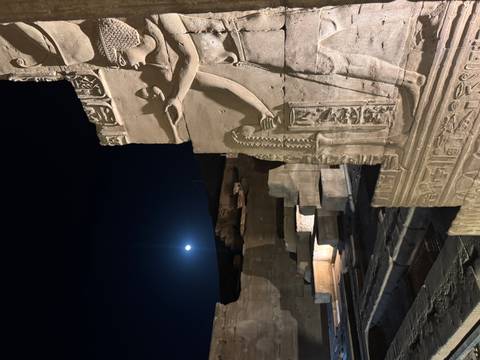 Night view of ancient carvings with a full moon.