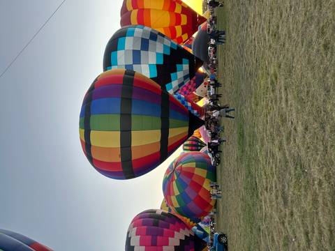 Large colorful hot air balloons with people enjoying the scene.