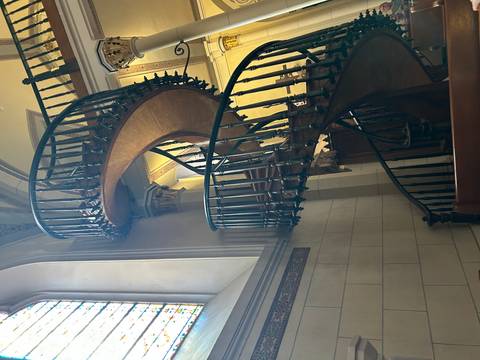 Curved wooden staircase inside a historical building.