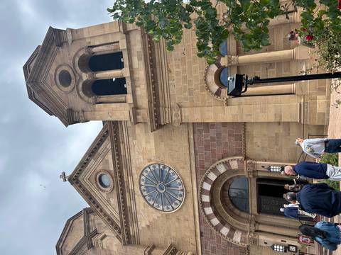 Exterior of a historic church with people walking nearby.