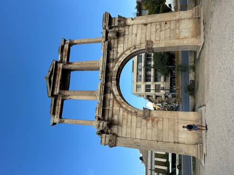 Hadrian's Arch in Athens with a person standing nearby.