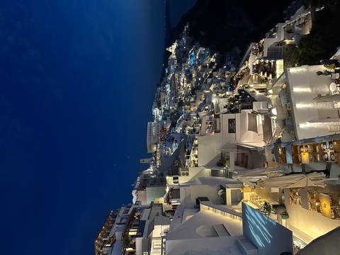 Night view of Santorini with illuminated buildings on the cliff.