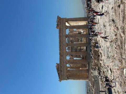 Tourists exploring the Parthenon ruins with clear blue sky.