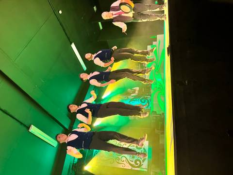       A group of performers doing a traditional Irish dance on stage.
  