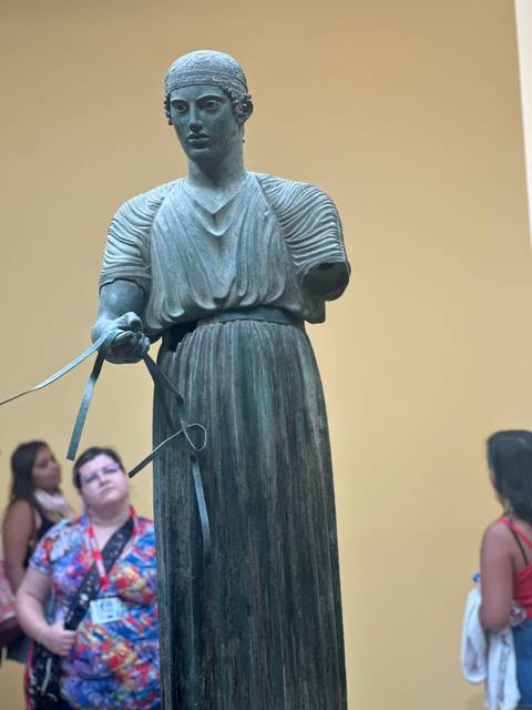       Museum statue with people observing
  