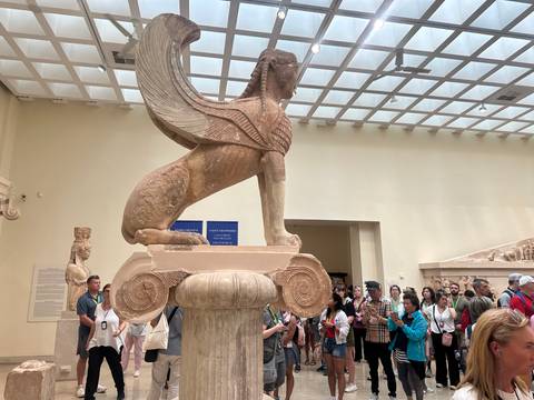       Visitors looking at a museum sphinx statue
  