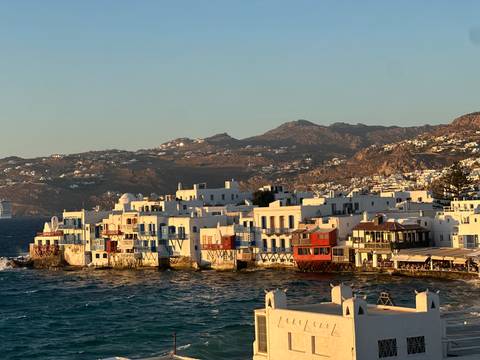       Mykonos harbor view with white buildings and sea
  