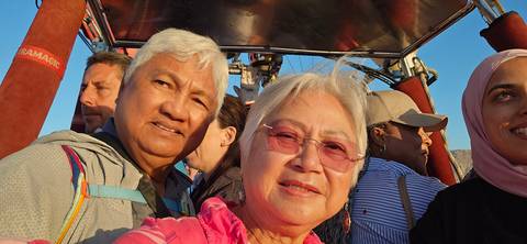       Group of people in a hot air balloon basket.
  