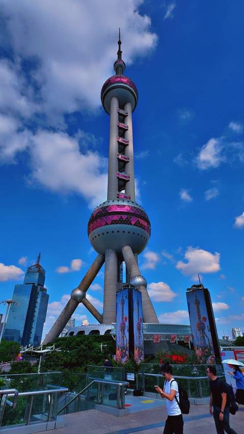       The Oriental Pearl Tower under a blue sky.
  