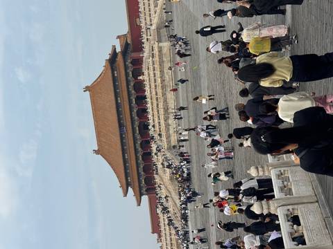       Crowds of people visiting a historical site with traditional architecture.
  