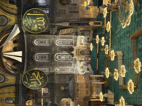       Interior of famous mosque with ornate decorations and chandeliers.
  
