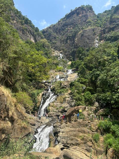       Lush green landscape with a waterfall.
  