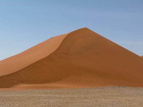       Large sand dune in a desert landscape.
  