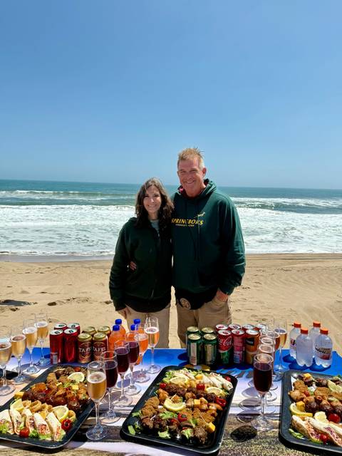       Two people on a beach with the ocean in the background.
  