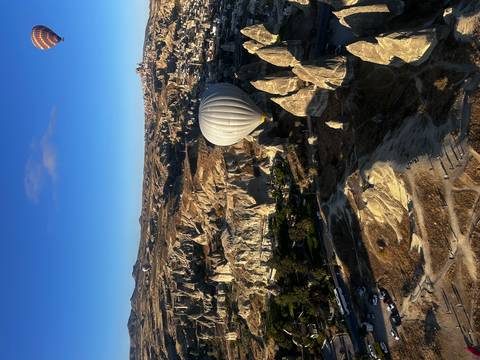 Hot air balloon floating over a rocky landscape.