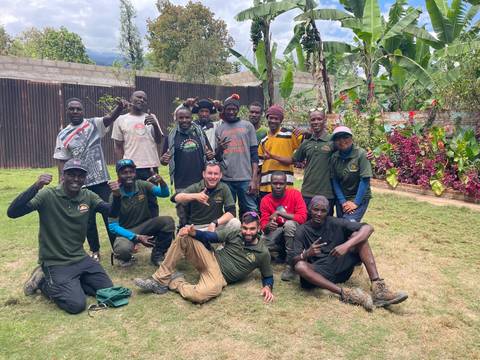 Large group of people posing together outdoors.