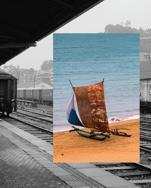 Train station with a beach and a traditional boat on the sand.