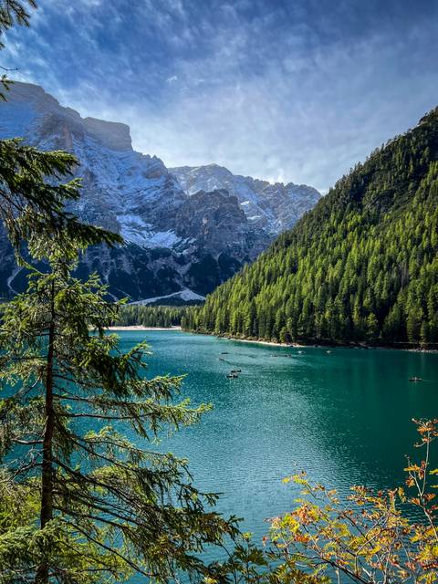 Calm lake with boats and surrounding trees.