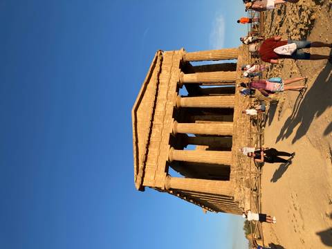 Tourists exploring a classical temple with columns.