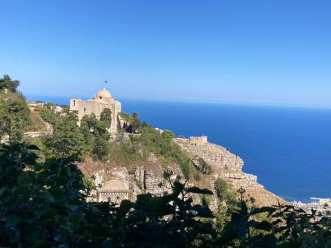 Hilltop town with historic structures overlooking the sea.