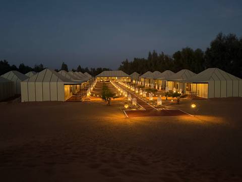 Luxury desert camp illuminated at night.