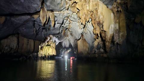       Inside a cave with impressive stalactites and stalagmites.
  