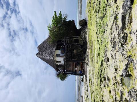 Unique restaurant situated on a rock surrounded by low tide water.