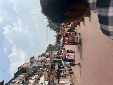 Busy street scene with people and rickshaws.