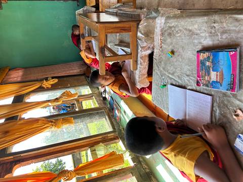       Young monks studying in a classroom with natural light.
  